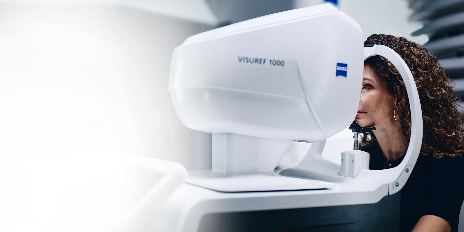 Nainen katsoo ZEISS VISUREF 1000 -laitteen läpi.