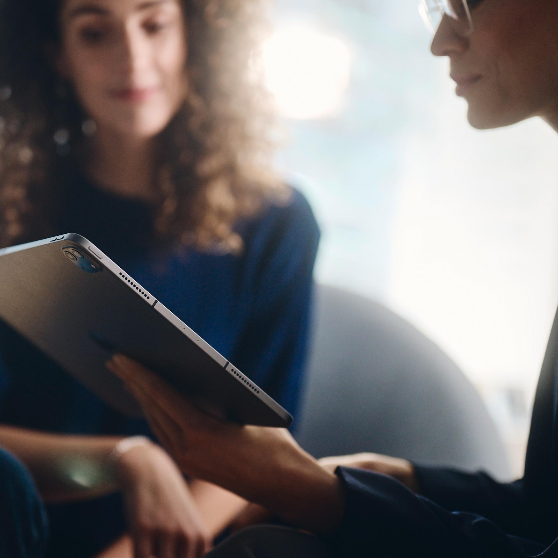 Kaksi naista katsoo tablettia.