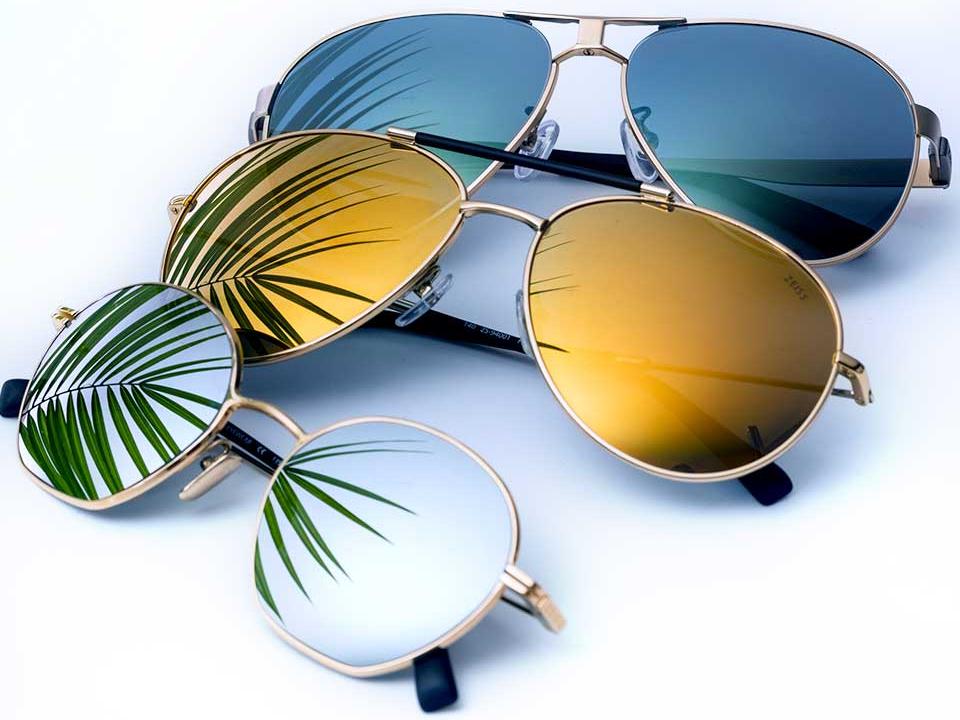 Valokuva kolmista aurinkolaseista, joiden linsseissä on eri värinen peilipinnoite (kirkas, keltainen ja sininen) 