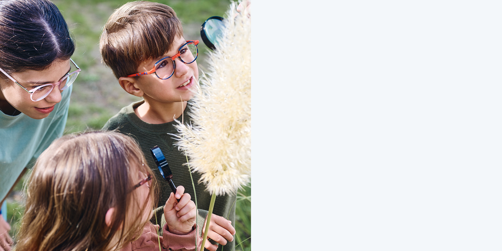 Kaksi tyttöä ja yksi poika, joilla on ZEISS MyoCare -linssit. Lapset katsovat kasvia, kaksi heistä katsoo kasvia suurennuslasien läpi.