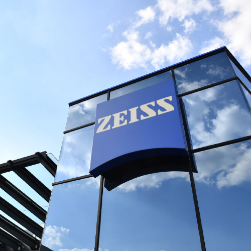 Kuva modernista lasirakennuksesta, jossa on suuri ZEISS-logo. 
