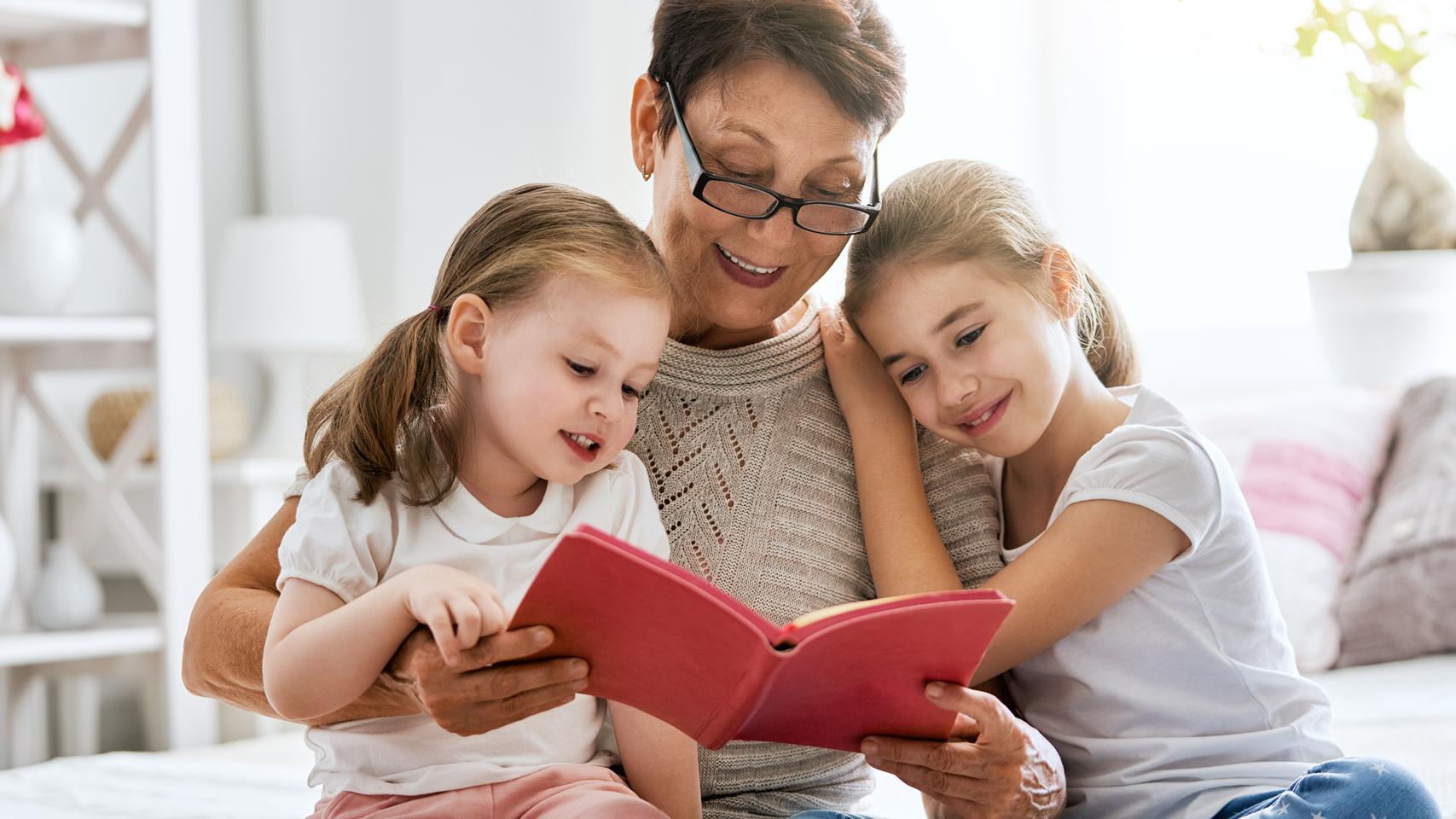 Isoäiti lukee kirjaa lapsenlapsilleen