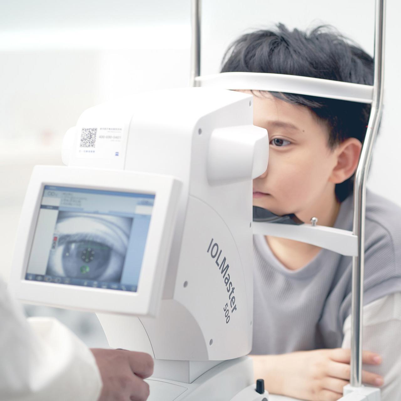 Poika näöntarkastuksessa, jossa käytetään ZEISS IOLMaster 500 -laitetta
