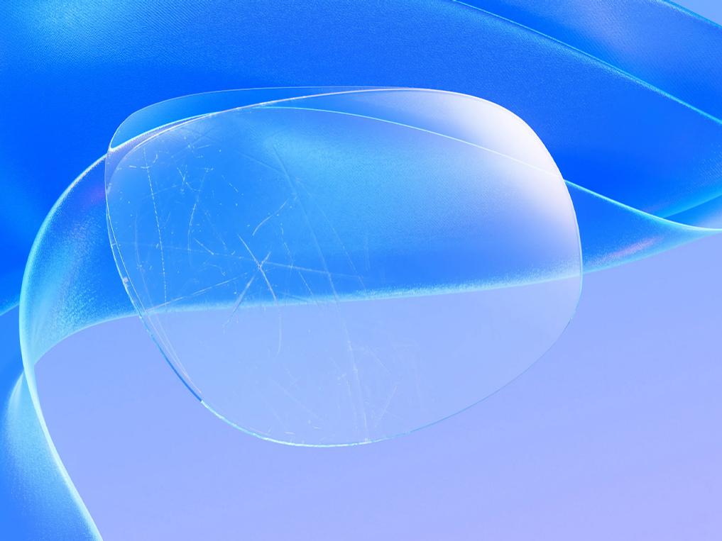 Graafinen 3D-esitys naarmuuntuneesta silmälasilinssistä, jonka päälle levitettävä ohut pinnoite käytännössä peittää naarmut ja tekee linssin pinnasta kirkkaan ja koskemattoman.