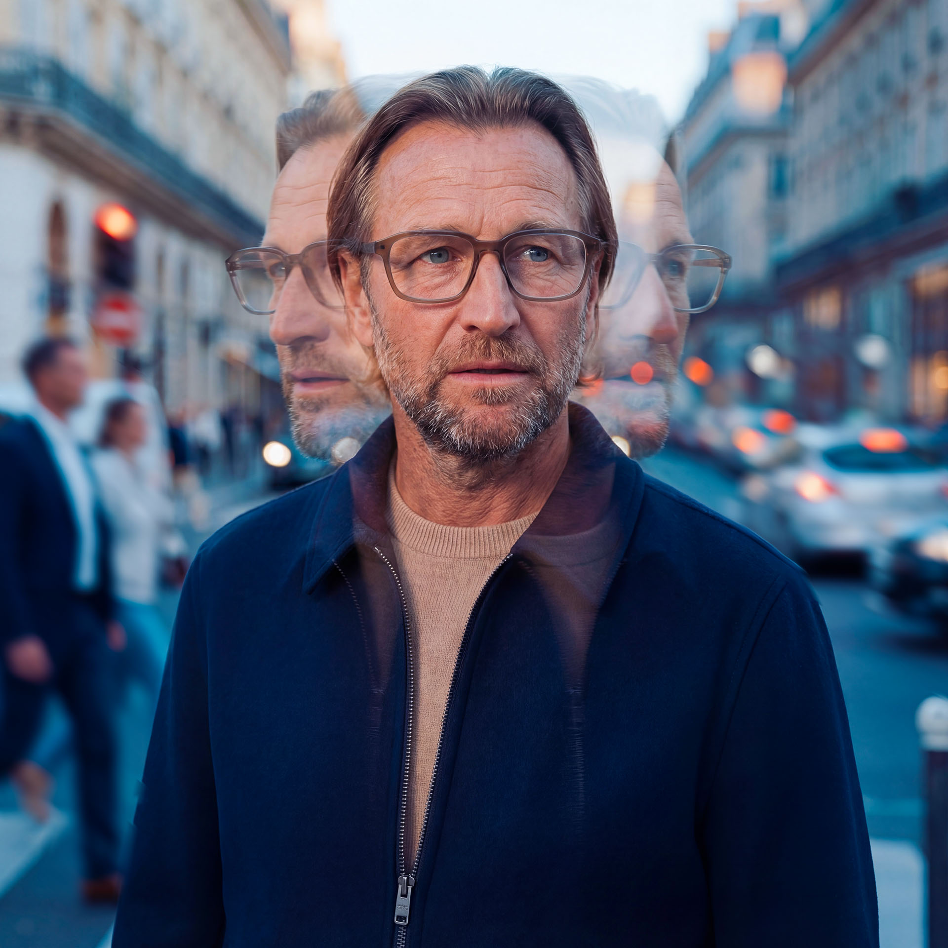 Perinteisiä silmälaseja käyttävä henkilö kiireisellä kadulla kuvassa, jossa on monivalotuselementtejä. 