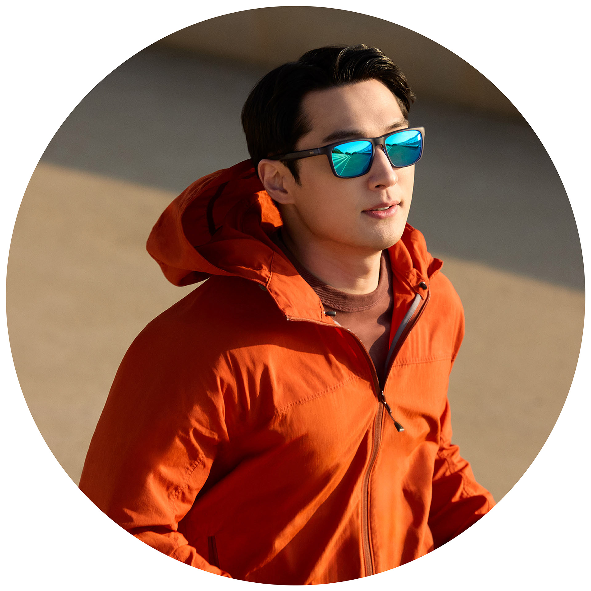 Oranssitakkinen hölkkääjä, jolla on ZEISSin aurinkolasit vahvuuksilla ja sinisellä peilipinnoitteella.