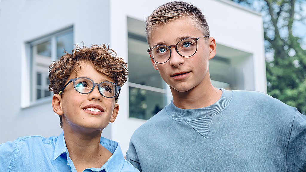 Nuori poika katsoo teinipoikaa, ja molemmilla on ZEISS Single Vision SmartLife Young -silmälasit.